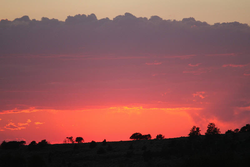 A fiery orange sunset under heavy clouds